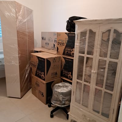 ארון וקרטונים עטופים בניילון בחדר ריק