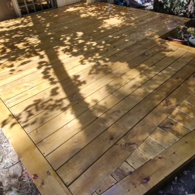 דק עץ בגינה עם עציצים מסביב