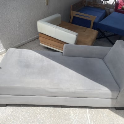 ספה אפורה על רצפת מרפסת עם אור שמש