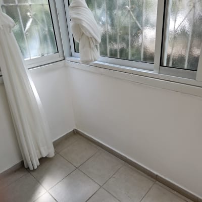 חלון עם וילון לבן בחדר מואר