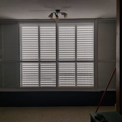 חלון עם תריסי אלומיניום בחדר חשוך