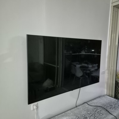 טלוויזיה מותקנת על קיר עם כבל חשמל מחובר