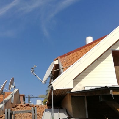 גג רעפים עם אנטנות לוויין ודוד שמש