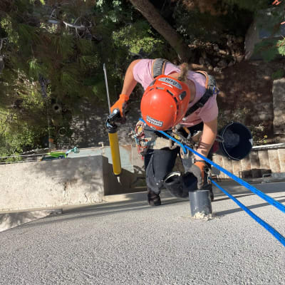 אדם עם קסדה אדומה אוטם קיר בעזרת מזרק צהוב