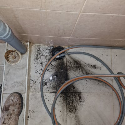 צינור ניקוז על רצפה מלוכלכת עם לכלוך שחור
