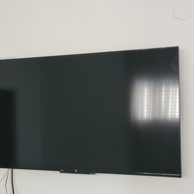 טלוויזיה תלויה על הקיר עם כבלים חשמליים