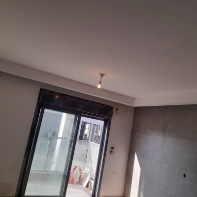 קיר גבס עם חיפוי חלק ליד חלון זכוכית