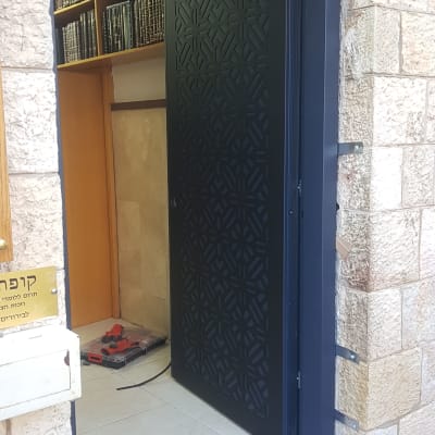 דלת שחורה עם דוגמה גיאומטרית פתוחה למחצה