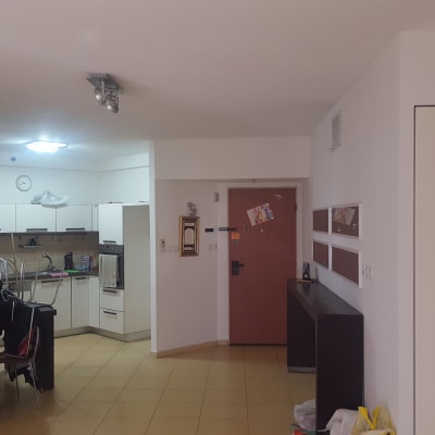 מטבח עם ארונות לבנים וכלי ניקוי על הרצפה