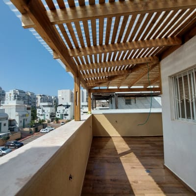 פרגולה מעץ על מרפסת עם רצפת עץ