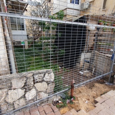 גדר מתכת עם מסגרת מול גינה קטנה