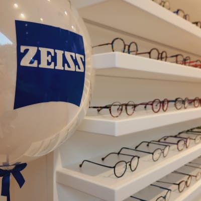 משקפיים על מדפים לבנים עם בלון ממותג