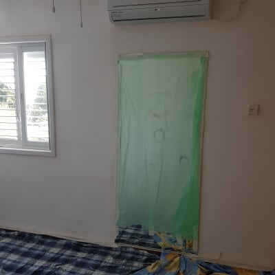 יריעת ניילון ירוקה מכסה דלת בחדר צבוע