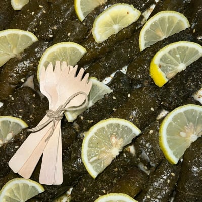 עלי גפן ממולאים עם פרוסות לימון וסכו"ם עץ