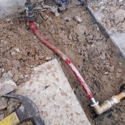 צינור מים אדום עם מחבר מתכת על רצפה