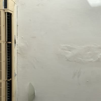 קיר עם תיקוני טיח ליד מזגן ישן