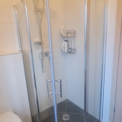 מקלחון זכוכית עם ראש מקלחת ומדף מוצרים