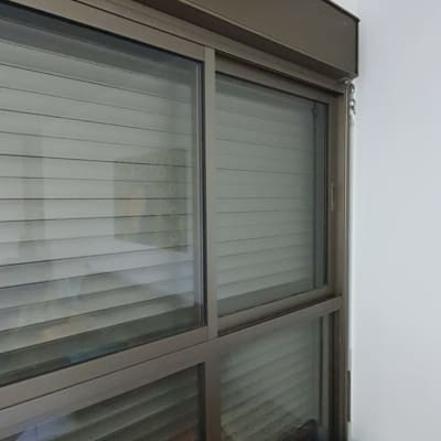 תריסים סגורים על חלון זכוכית עם מסגרת מתכת