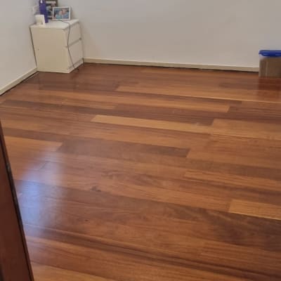 רצפת פרקט עץ כהה בחדר ריק עם קיר לבן