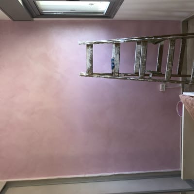 קיר צבוע בוורוד עם סולם צביעה