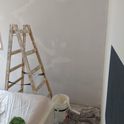 סולם עץ, דלי צבע, קיר צבוע חלקית