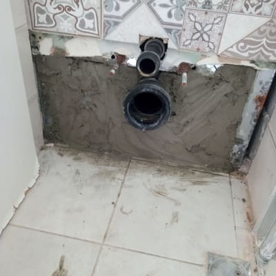 צינור ביוב מותקן בקיר עם אריחים