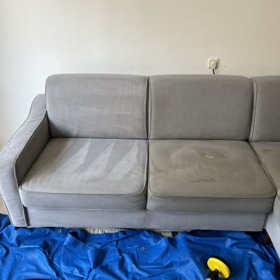 ספה אפורה עם סימני ניקוי, כלי ניקוי על יריעה כחולה