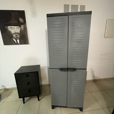 ארון אפור עם ידיות שחורות על רצפה מרוצפת