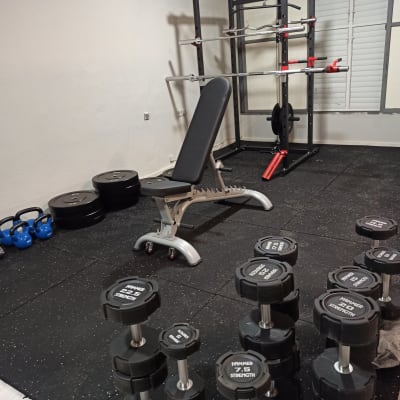 חדר כושר עם משקולות, ספסל ומתקן כושר