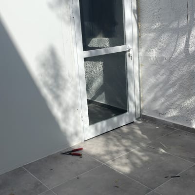 דלת אלומיניום עם חלון זכוכית על רצפת אריחים