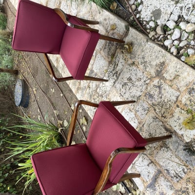 שני כיסאות מרופדים בבד אדום על שביל אבן