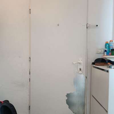 דלת מתכת עם ציפוי מתקלף בחלק התחתון