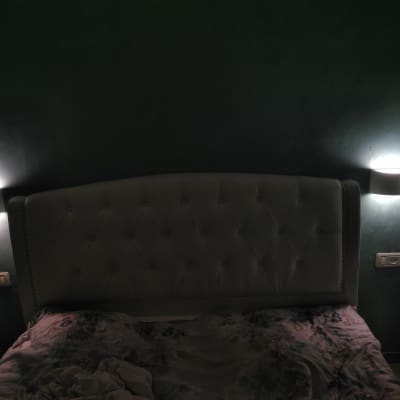 שני מנורות קיר דולקות מעל מיטה