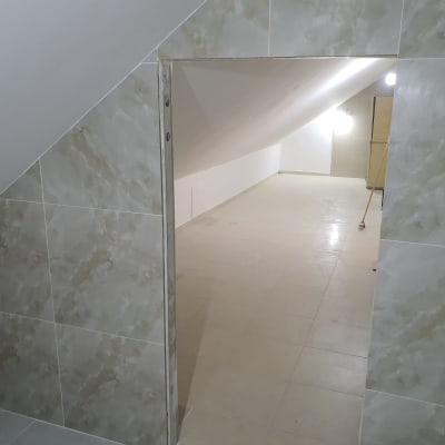 חדר עם קירות מרוצפים, רצפה חלקה ותאורה חזקה