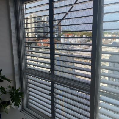 תריסי אלומיניום בחלון עם נוף עירוני