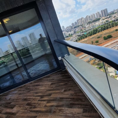 מרפסת עם רצפת עץ נקייה ומעקה זכוכית