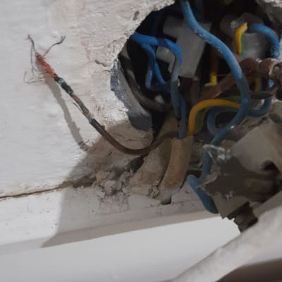 חוטי חשמל צבעוניים יוצאים מקיר