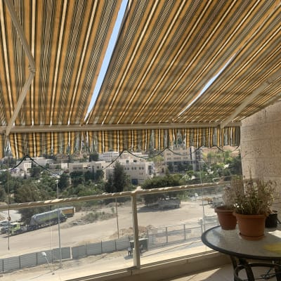 סוככים מפוספסים בצבעי צהוב וחום על מרפסת