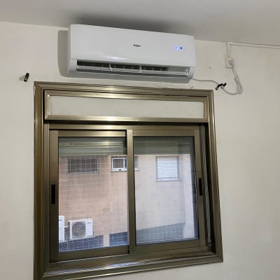 מזגן מותקן מעל חלון עם חיווט חשמלי גלוי