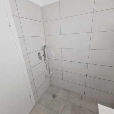 מקלחת עם אריחים חדשים וראש גשם מותקן