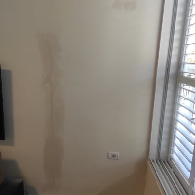 קיר עם תיקוני טיח ליד חלון