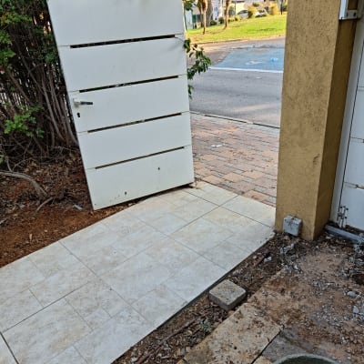 שביל מרוצף חדש ליד שער לבן פתוח