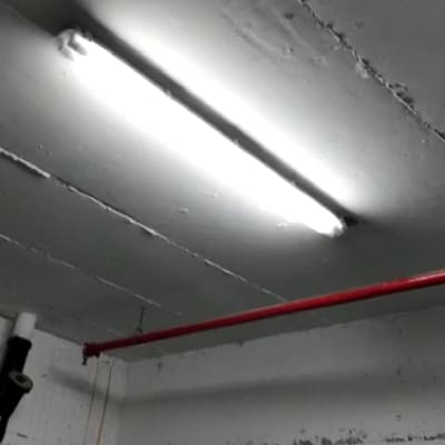 תאורת פלורסנט מותקנת על תקרה עם צינור אדום
