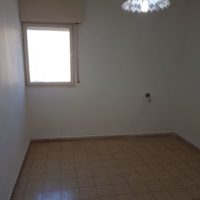 חדר ריק עם קירות צבועים בלבן ותקרה עם מנורה