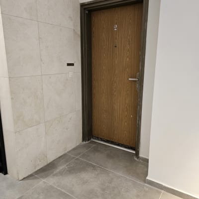 דלת עץ חדשה עם מסגרת מתכת, רצפת אריחים אפורה