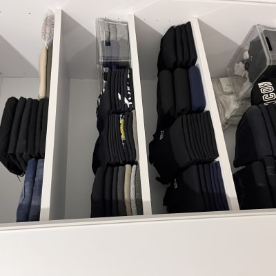 בגדים מקופלים ומאורגנים במדפים לבנים בארון