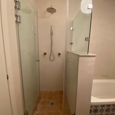 מקלחת עם דלת זכוכית וראש מקלחת עגול