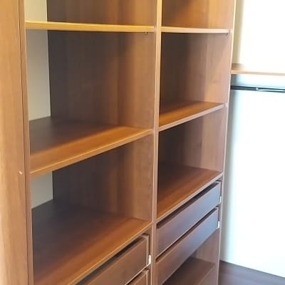 ארון עץ ריק עם מדפים ודלתות פתוחות