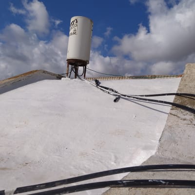 גג אטום עם חומר איטום לבן וצינורות חשמל