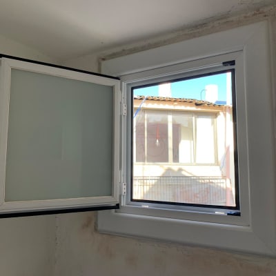 חלון אלומיניום פתוח עם מסגרת לבנה